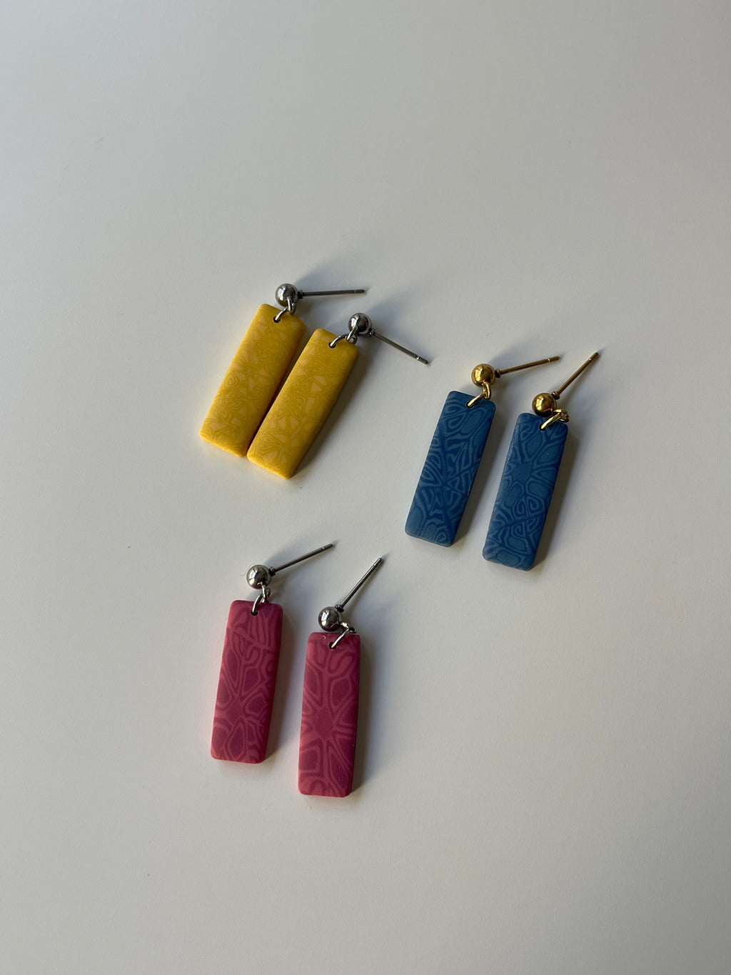 Pendientes rectangulares con estampado rosa, azul y amarillo de arcilla polimérica y acero inoxidable