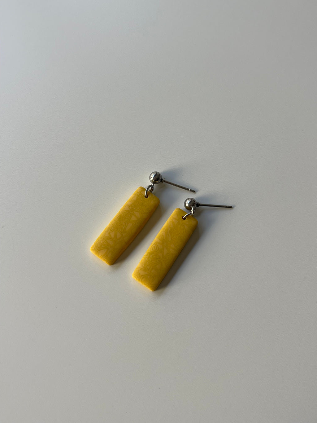 Pendientes rectangulares con estampado amarillo de arcilla polimérica y acero inoxidable
